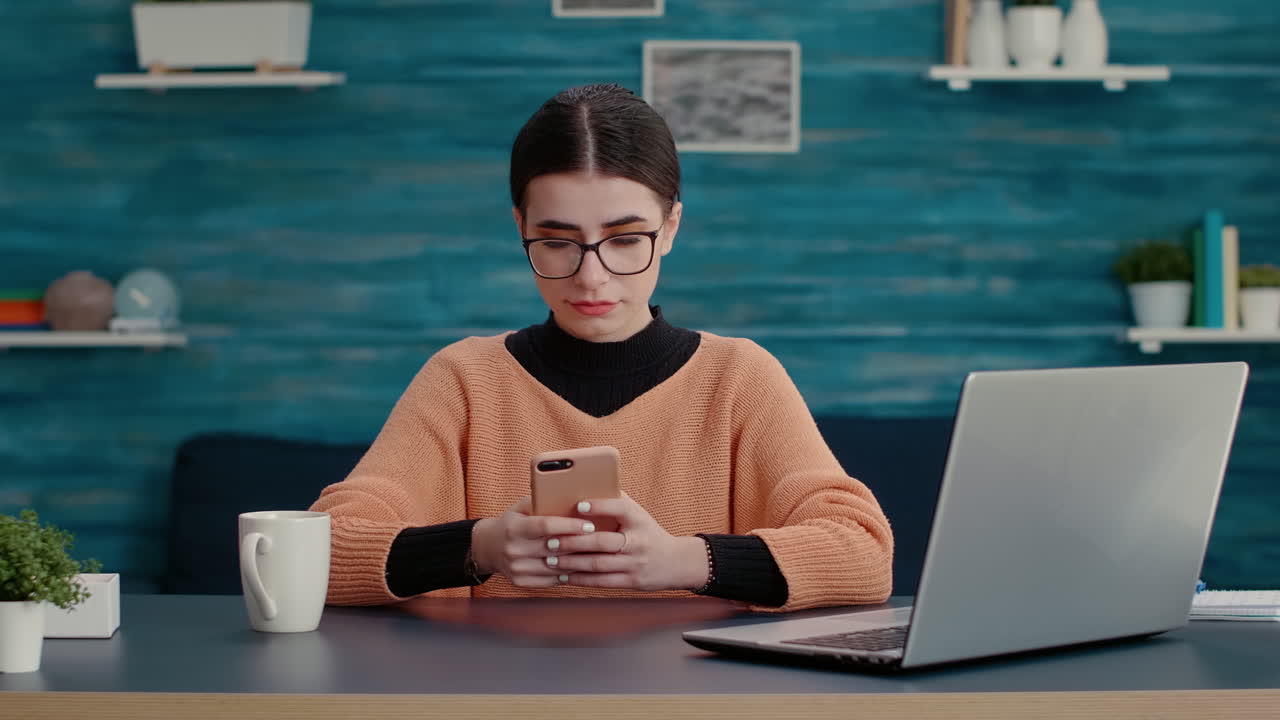 Person sitting at desk and using smartphone to browse internet