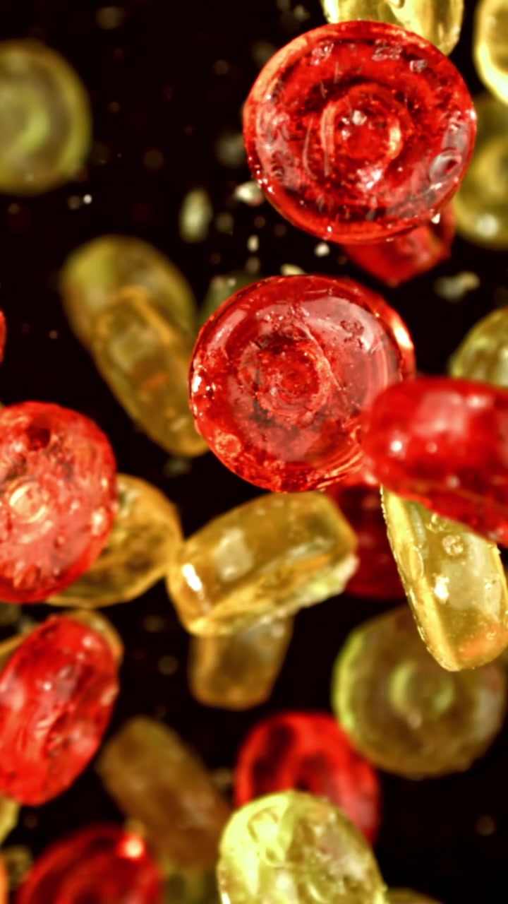 Caramelle rosse e gialle che cadono al rallentatore