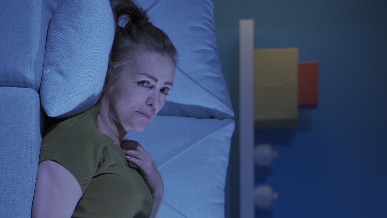 el video vertical de la mujer acostada en el sofá está llorando.