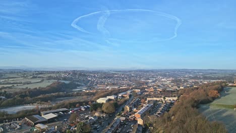 Cold-winter-aerial-footage-of-a-town-city-landscape,-with-low-afternoon-lighting-and-freezing-sunlit-houses