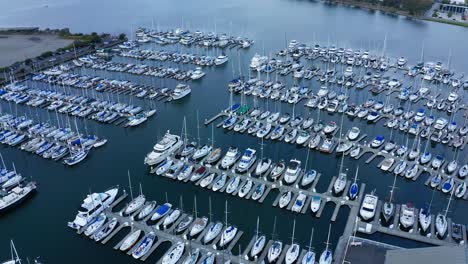 sailboats in their slips in a marina and a port shipping and luxury