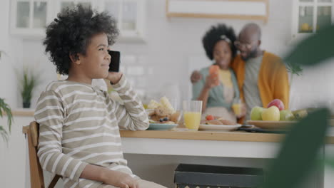 kid talking on phone during family breakfast