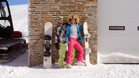 Cute-couple-leaning-against-ski-resort-garage