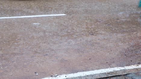 Close-up-of-Filipino-tricycle-taxi-wheels-on-wet-road-during-heavy-rain-monsoon-weather-in-Palawan,-Philippines,-Southeast-Asia