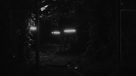 man walking through a dark tunnel at night