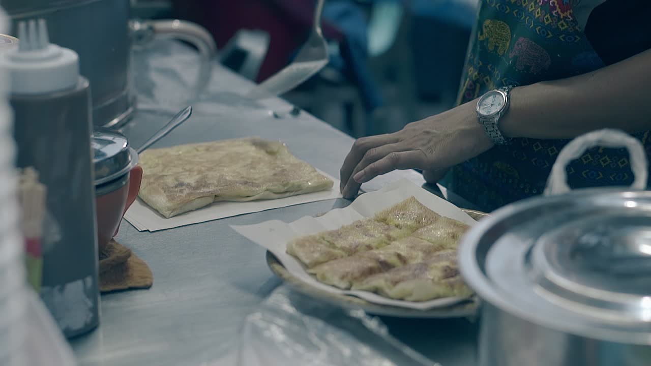un joven pone pastel con corteza dorada en papel blanco
