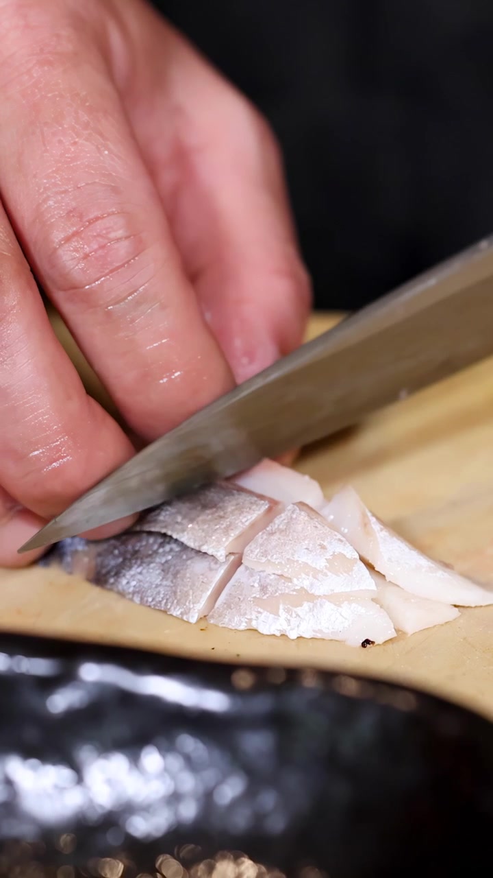 Close-up of Chef Slicing Fresh Fish Fillet on a Wooden Cutting Board