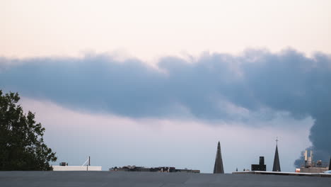 timelapse of a smoke column rolling over the roof of antwerp, belgium