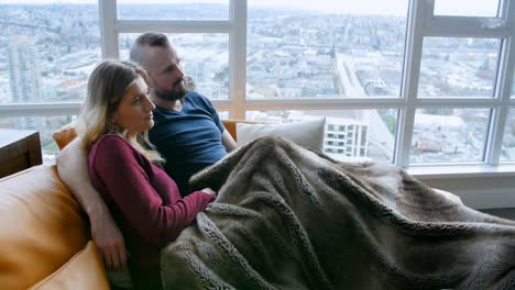 couple watching television together in living room 4k