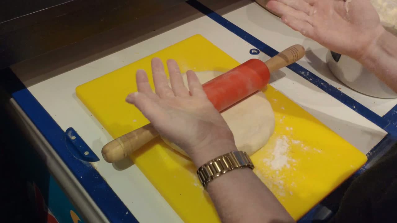 Esperta artigiana impasta la pasta con farina di grano con le mani e un mattarello per preparare biscotti biologici nel forno, l'area di lavoro della sua attività di catering. Faro bloccato, Ordini, Galizia, Spagna