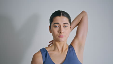 mujer deportiva estirando las manos en casa de cerca. mujer en forma calentándose haciendo ejercicio