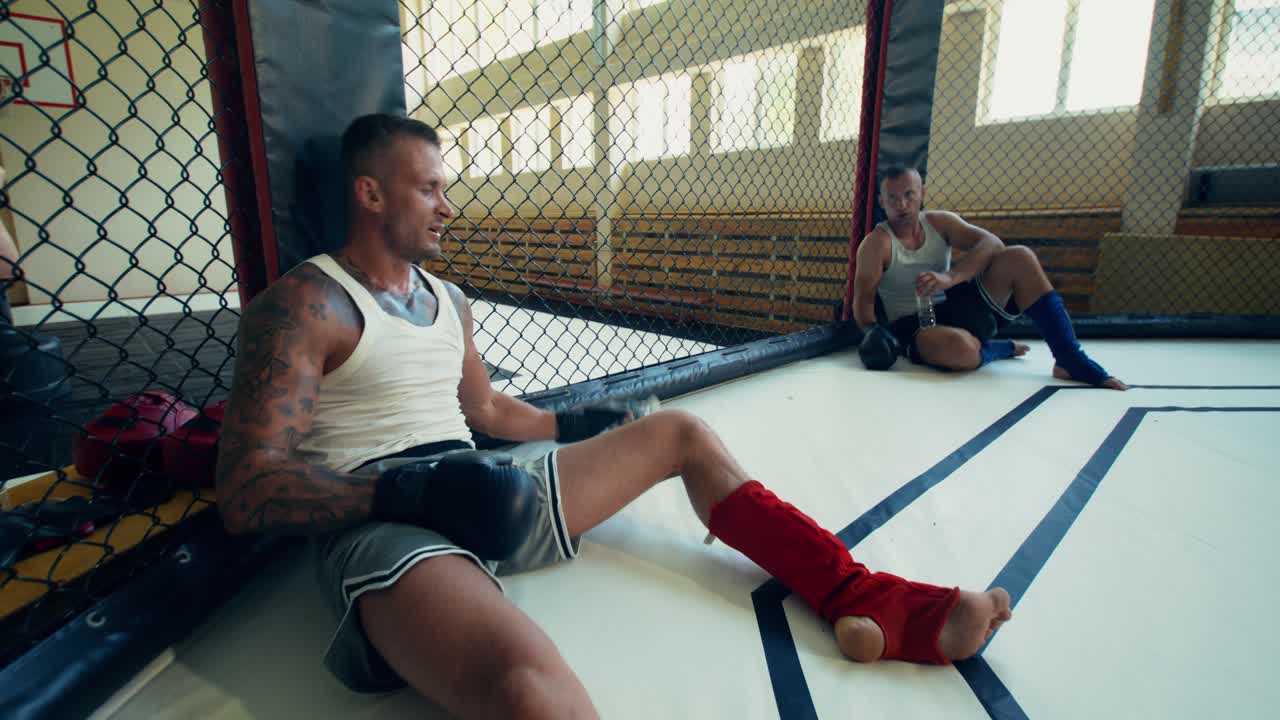 MMA-vechters die uitrusten in een kooi
