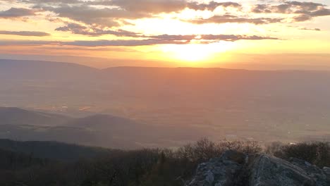 sun setting over mountains stock