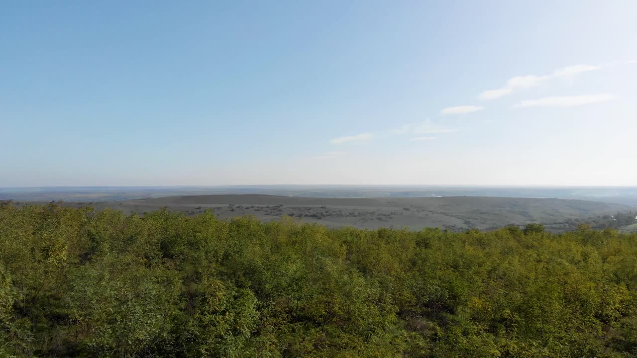 언덕 위의 푸른 숲 위로 공중 전망을 감상하며 초원과 들판이 있는 계곡, 햇살 가득한 여름날 - 돌리, 드론 샷