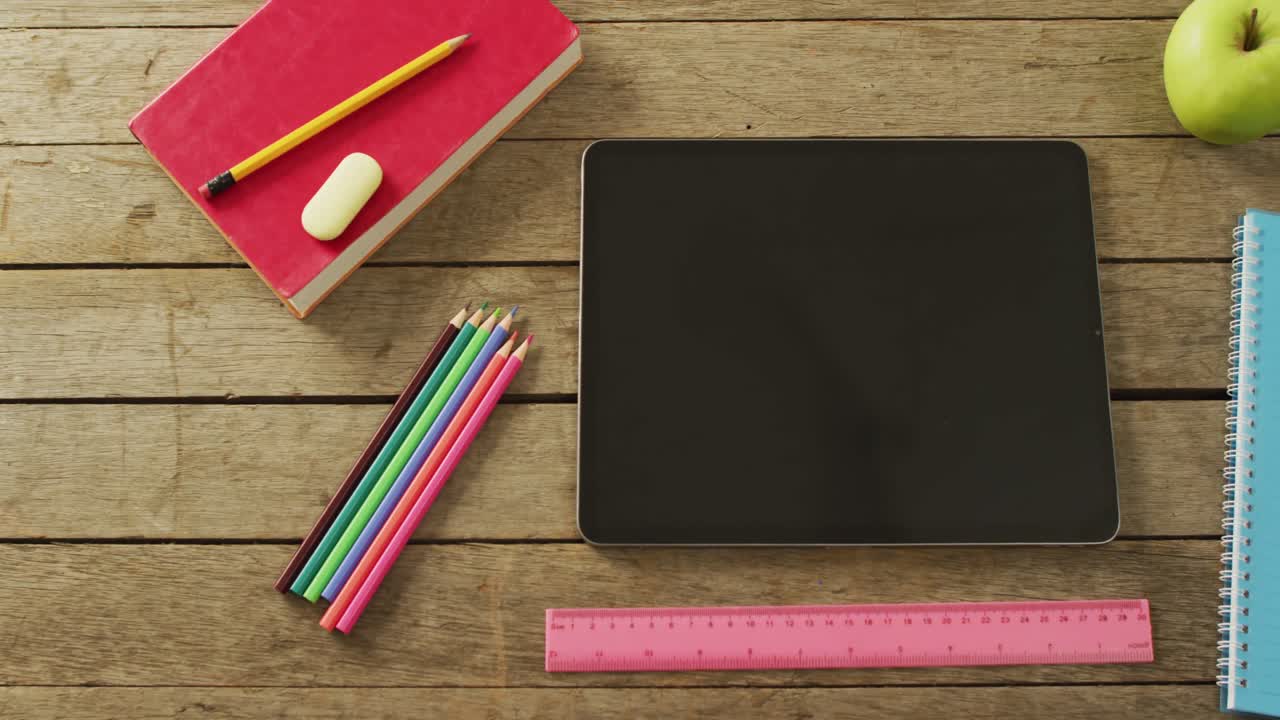 Video of tablet with copy space and school items on wooden background