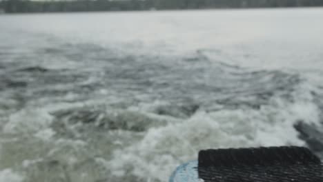 close up panning shot of surf board to lake view on a boat