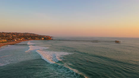 el paraíso de los surfistas de san diego con el icónico muelle de la playa oceánica en la distancia, drone aéreo