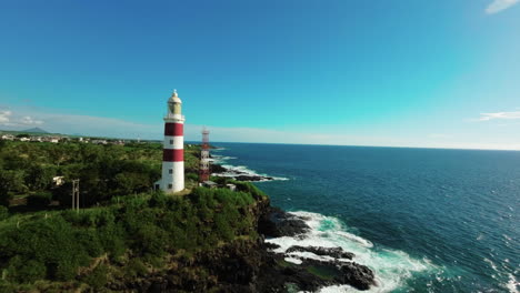 avión no tripulado de fpv volando más allá del faro de la playa de albion en mauricio desde el aire