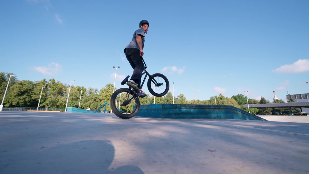 Ragazzo che esegue un trick manual in BMX in uno skatepark