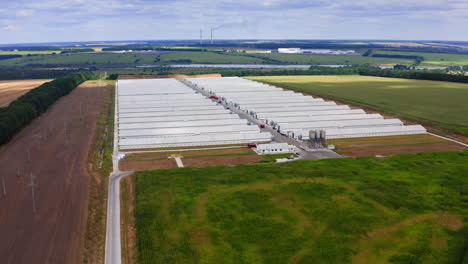 innovative farm on field in the countryside. large agricultural area on beautiful green landscape. harmful factory among nature. aerial view.