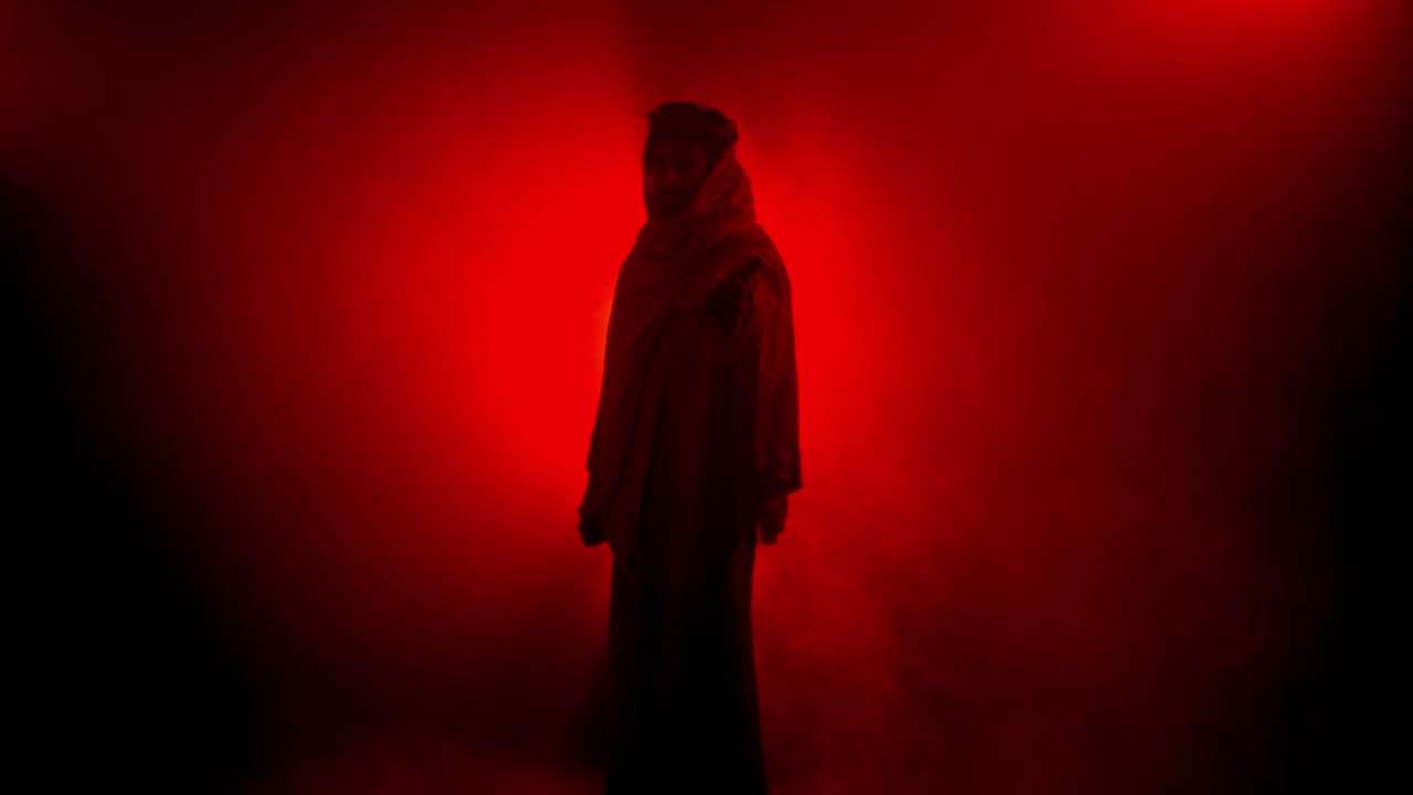 Dramatic, abstract silhouette of Jesus Christ in red glowing light for Christianity, Easter visual, bible scene or temptation, prayer, worship visual.