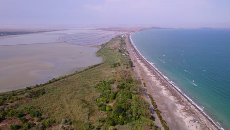 aerial view of a coastal landscape with beach, sea, and salt flats