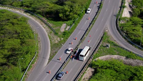 drone pullback as workers repair metal median barrier on highway