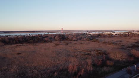 A-beautiful-aerial-drone-shot,-flying-towards-a-water-tower-during-the-golden-hour-in-Cape-May-New-Jersey,-Cape-May-County