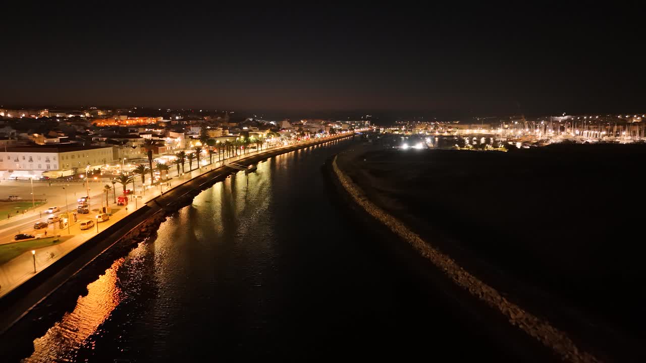 Aerial view of Lagos, Portugal at night, with the Bensafrim river reflecting the city lights. Push Forward