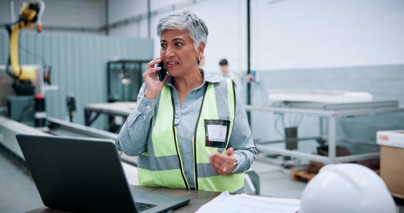 Female Factory Manager Talking on Phone in Industrial Facility