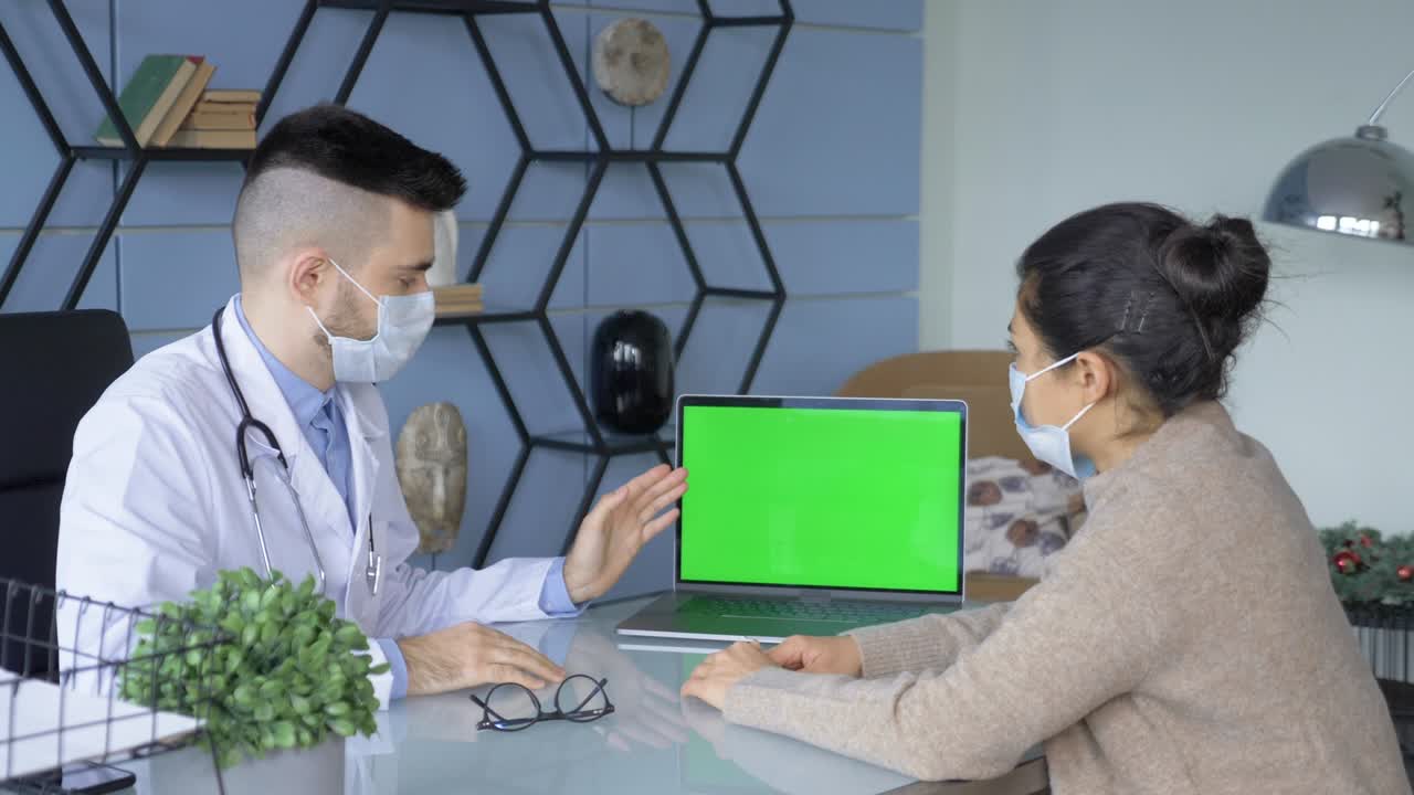 의사 는 병원 사무실 에서 녹색 스크린 디스플레이 를 가진 노트북 에서 환자 에게 어떤 것 을 보여 준다
