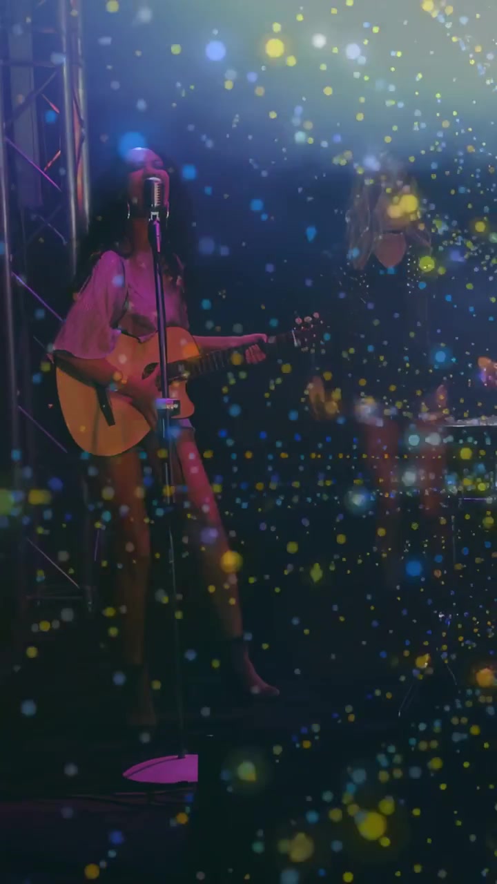 Vertikal video: Gitarist begynner å klimpre, sanger blir med, gnister fyller mikrofon, gitar og tangenter for musikk.
