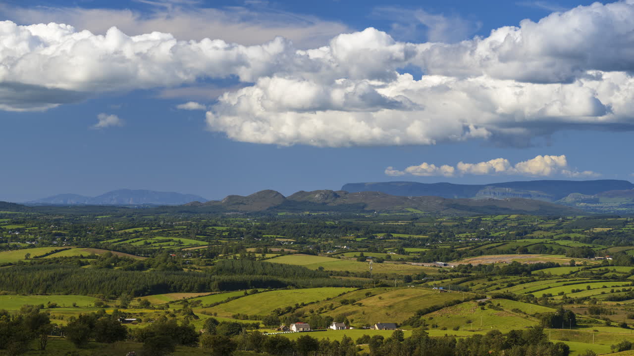 lapso de tiempo del paisaje agrícola rural con campos verdes, bosques, colinas y granjas en un día soleado de verano en irlanda