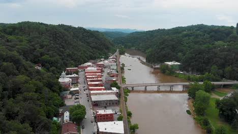 4k aerial drone video of the french broad river as it flows under the baileys branch bridge in historic marshall, nc (2021)