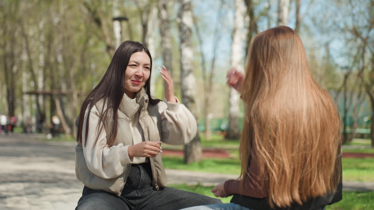 Mujer feliz sosteniendo un pequeño premio, la mujer sonríe ampliamente mientras agarra un pequeño trofeo en su palma, mujer alegre celebra su victoria agarrando un recuerdo en miniatura durante un día soleado en el parque