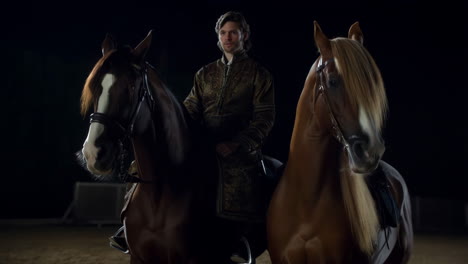 man in historical attire with two horses