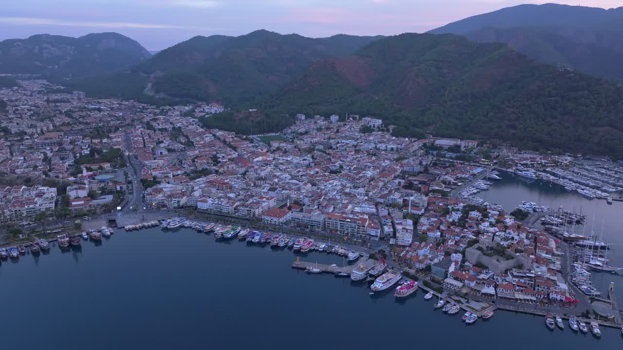 Vista all'alba della baia di Marmaris, fiancheggiata da resort e yacht, Turchia