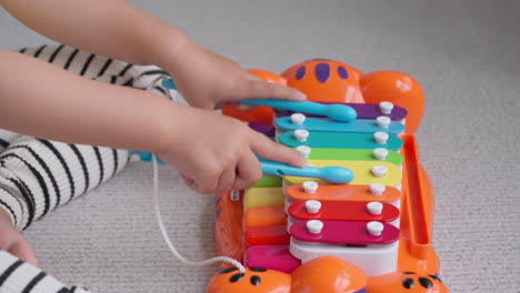 Child-Girl-Hands-Playing-on-Toy-Piano-and-Xylophone-Music-Instrument---close-up-slowmo