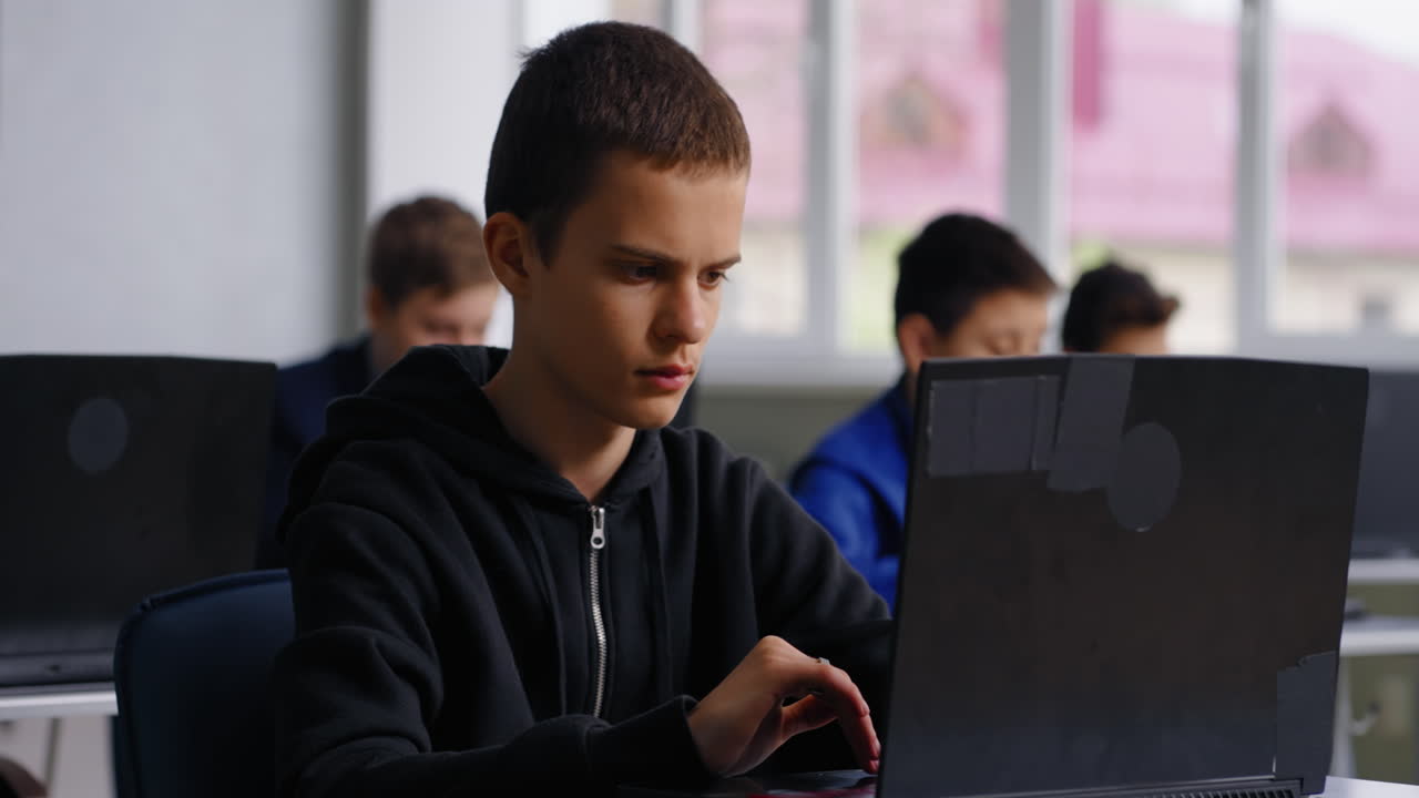Teenager Working on Laptop in Classroom