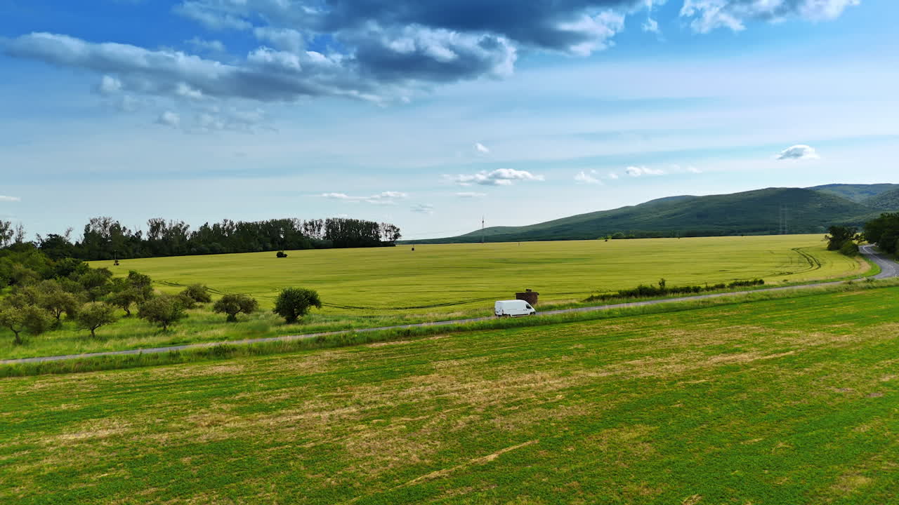 Expansive green fields under a blue sky. Vast fields of green stretch across the landscape under a bright blue sky, showcasing the beauty of rural Europe