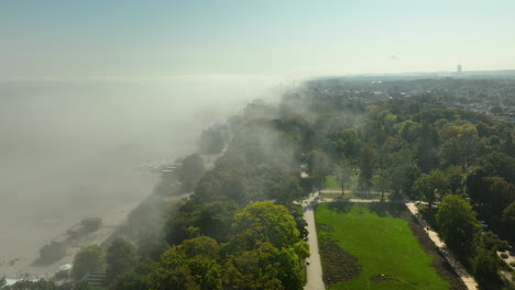 Aerial view of Sopot beach and city enveloped in fog, with faint visibility of buildings and coastline