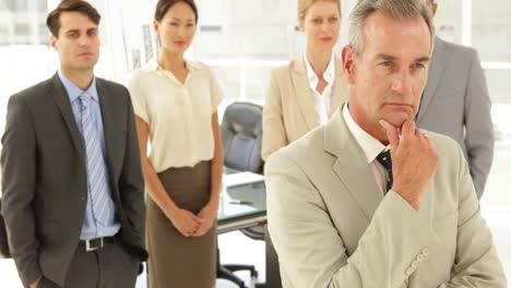 businessman thinking in front of his staff