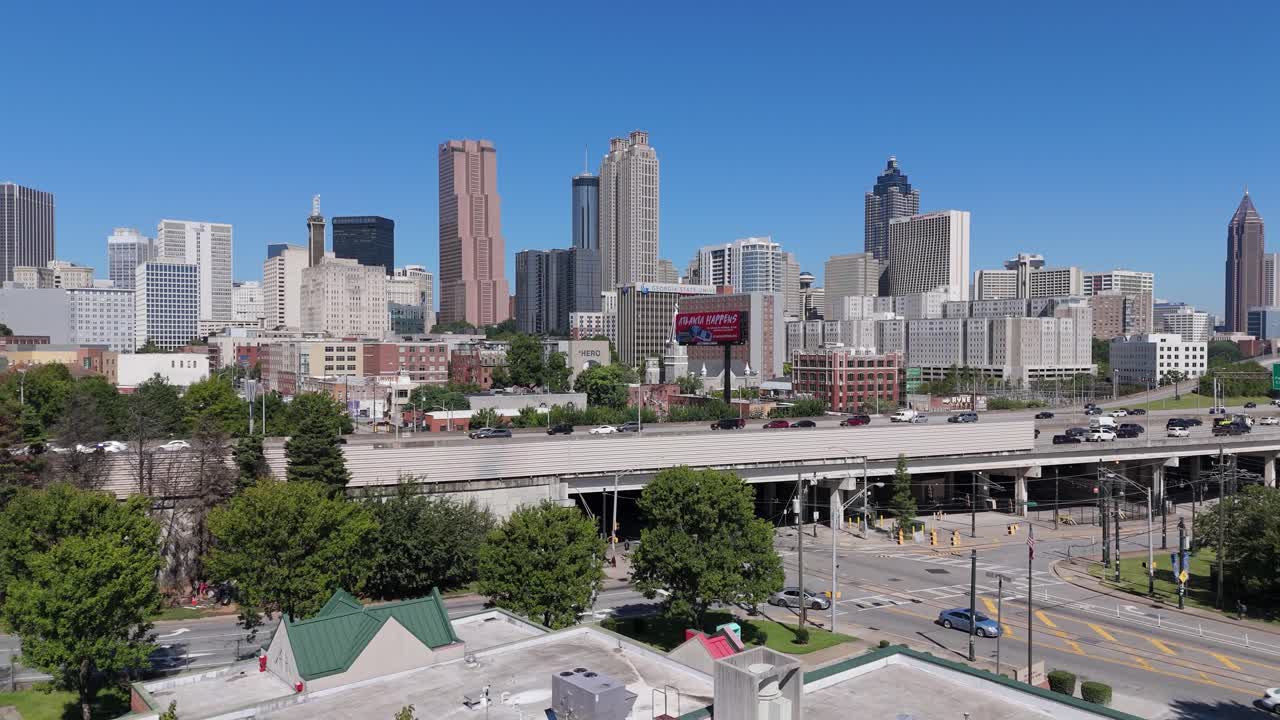여름날에 애틀랜타 시내의 스카이라인을 드러내기 위해 나무 위로 상승하는 드론