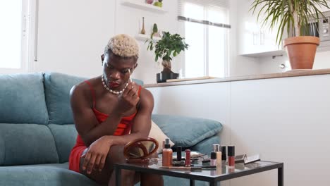 person in a red dress applying makeup at home