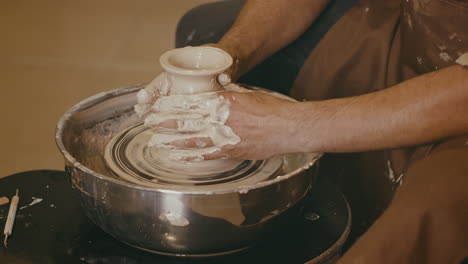 pottery artist shaping clay on a wheel