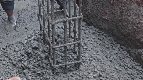 construction workers using trowel tool for leveling concrete at footing foundation. day time, zoom out shot, 4k
