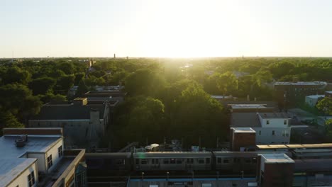 Drone-Flying-Backwards-over-Trees-Reveals-CTA-Subway-Train-in-Urban-Chicago-Neighborhood