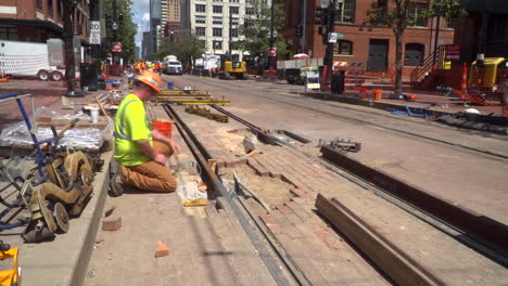 construction worker repairing tram tracks on a city street