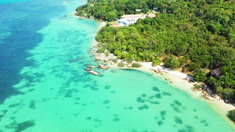 Beautiful-turquoise-lagoon-with-coral-reefs-washing-tropical-island-shore-with-cliffs-and-sandy-exotic-beaches-in-Thailand