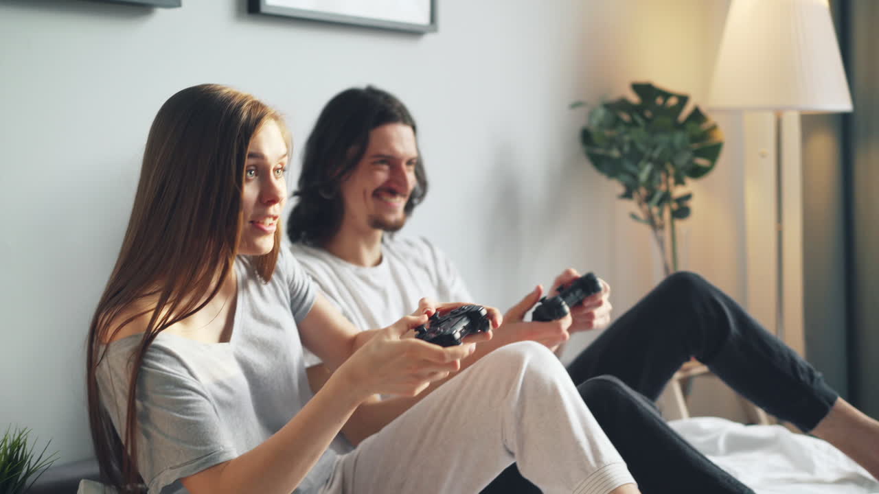 Coppia che gioca ai videogiochi su un letto